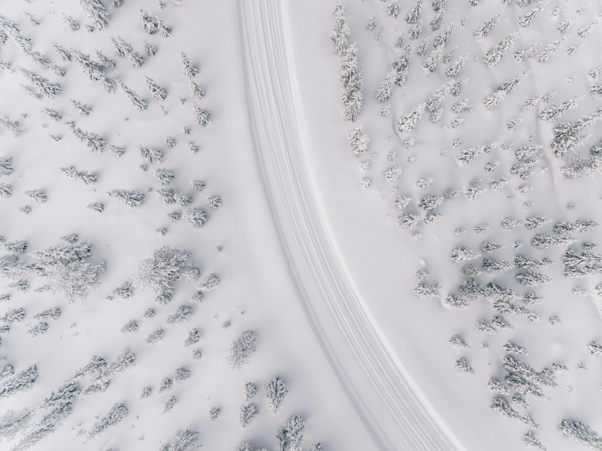 Aerial view of the road in the winter snow forest in Finland