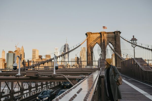 USA, New York, New York City, female tourist on Brooklyn Bridge in the morning light