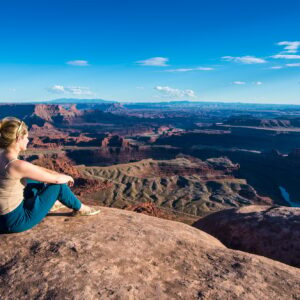 USA, Utah, Woman at a overlook over the canyonlands and the Colorado river from the Dead Horse State