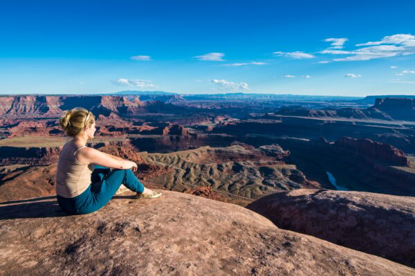 USA, Utah, Woman at a overlook over the canyonlands and the Colorado river from the Dead Horse State