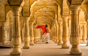 Young female tourist dancing at Pillars room of Amber Fort, Jaipur